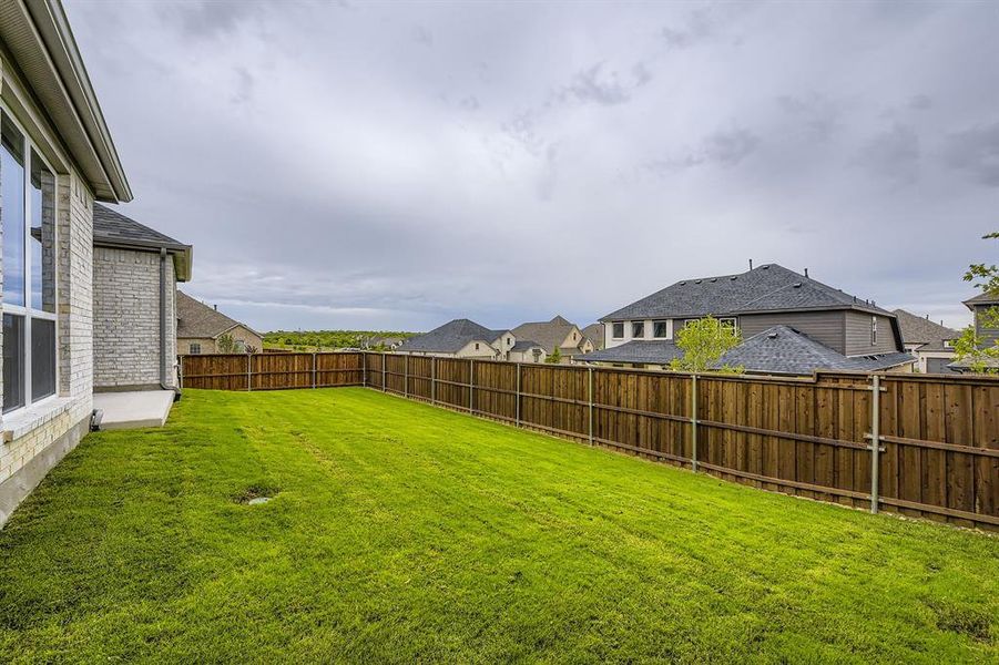 Fenced backyard featuring a residential view