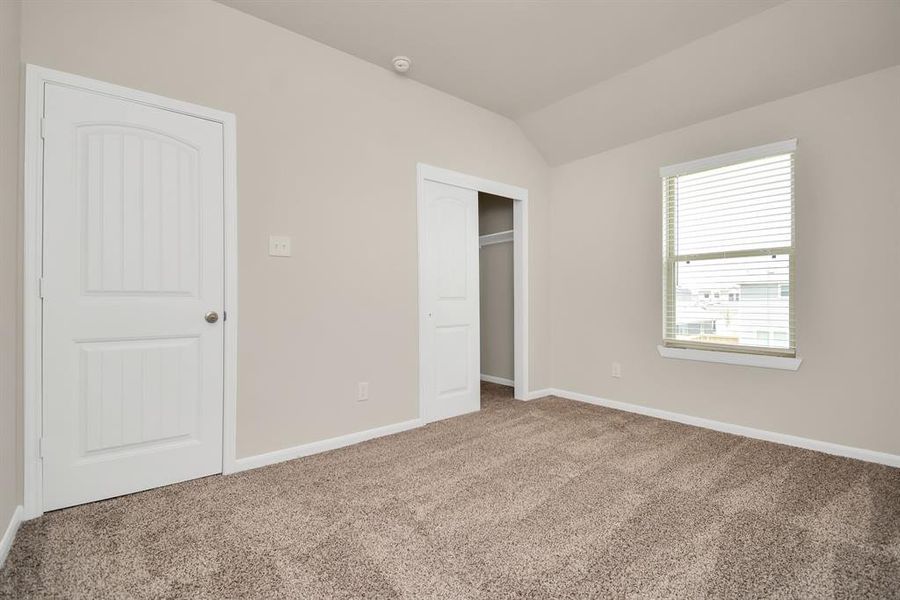 This light-filled fourth bedroom offers the perfect blend of comfort and functionality. The generous walk-in closet, in the corner of the room, ensures there's plenty of space to keep belongings organized **This image is from another Saratoga Home with similar floor plan and finishes, not the Brittany floorplan.**