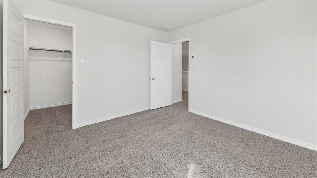 Unfurnished bedroom featuring a spacious closet and carpet
