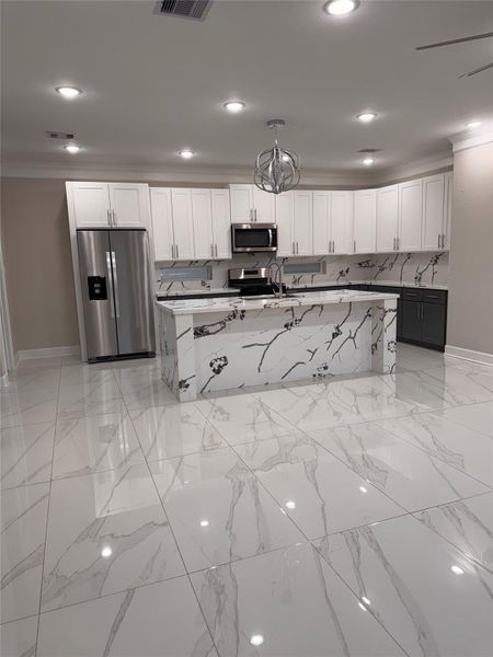 Stunning modern kitchen featuring sleek white cabinetry, elegant marble-patterned countertops and island, and stainless steel appliances for a sophisticated touch. Stunning modern kitchen featuring sleek white cabinetry, elegant marble-patterned countertops and island, and stainless steel appliances for a sophisticated touch.