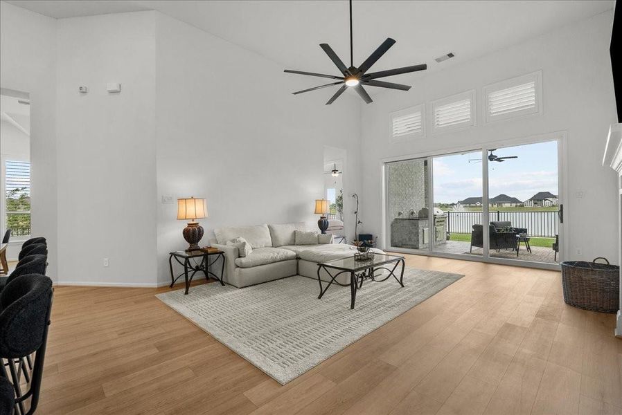 Living room showcases soaring ceilings, a cozy fireplace, and breathtaking water views.