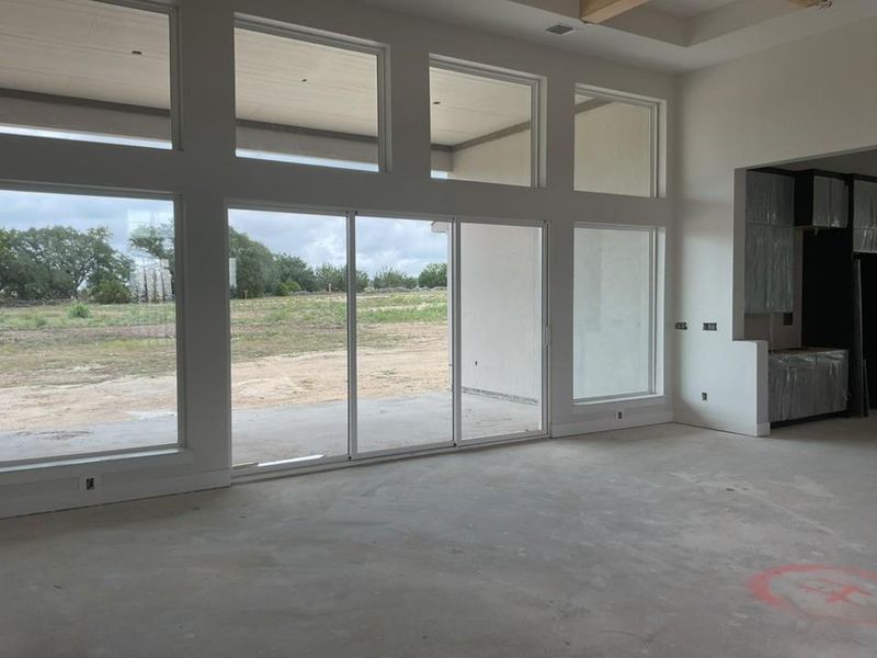Doorway featuring concrete flooring and a towering ceiling