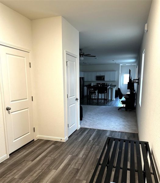 Hallway featuring dark wood-type flooring and baseboards