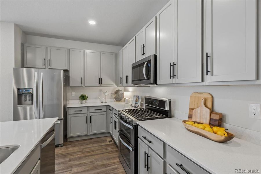 Soft grey cabinets, creamy quartz counters