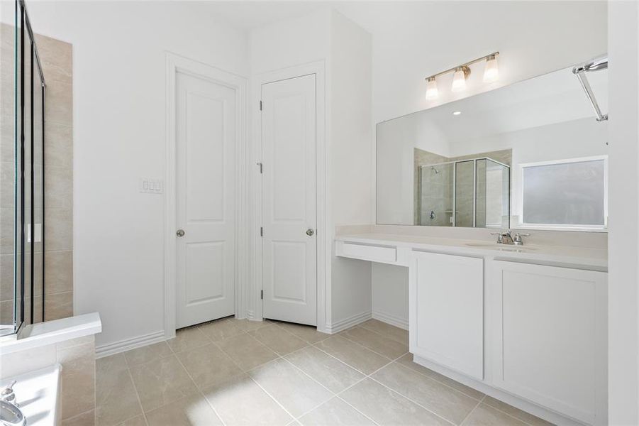 Bathroom featuring vanity, a shower stall, and light tile patterned flooring