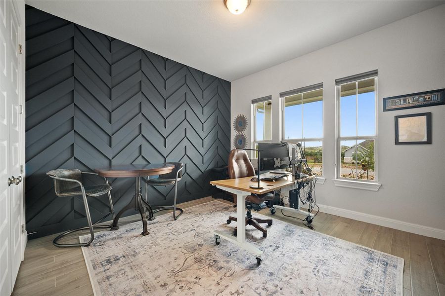 Office space with an accent wall and wood finished floors