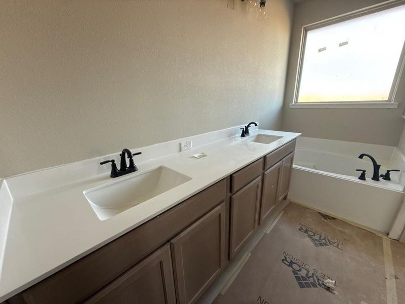 Full bath featuring double vanity and a garden tub