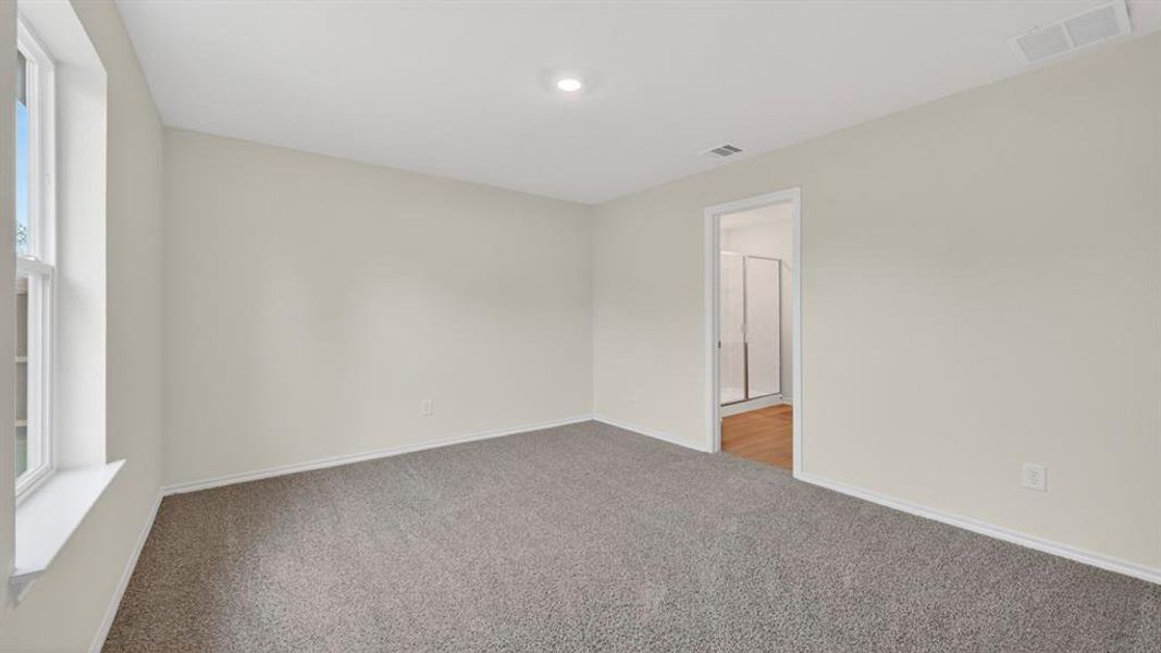 Spacious room with gray carpet flooring and neutral wall tones
