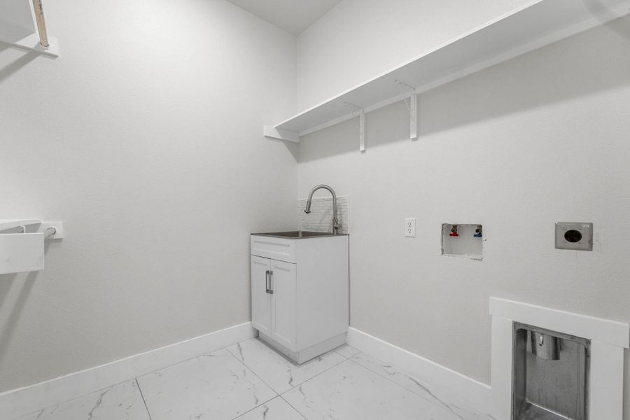 Laundry room featuring sink, hookup for an electric dryer, cabinets, and hookup for a washing machine