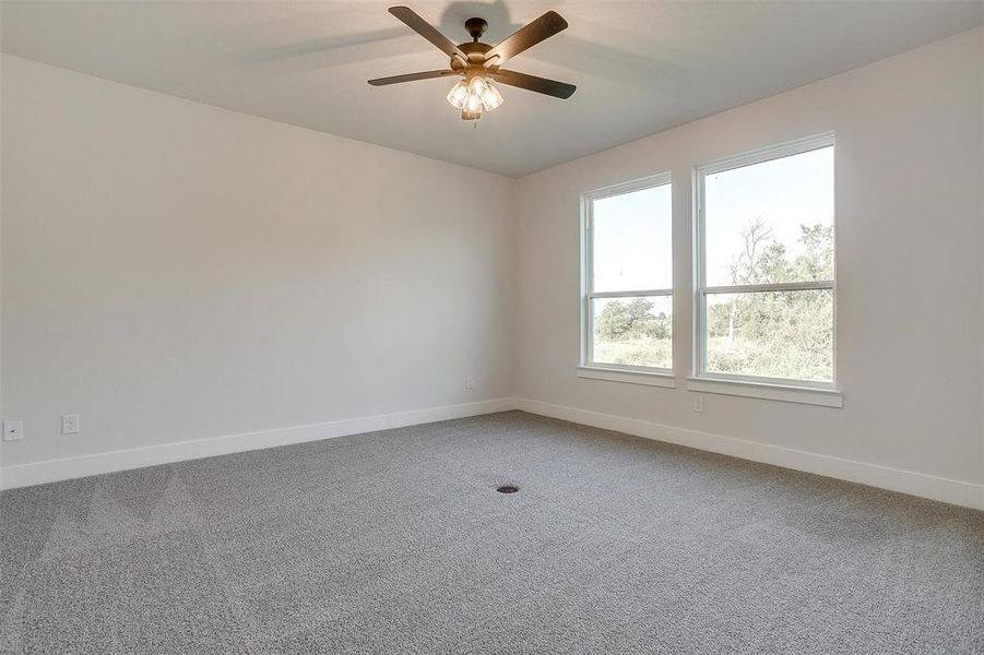 Carpeted empty room featuring ceiling fan