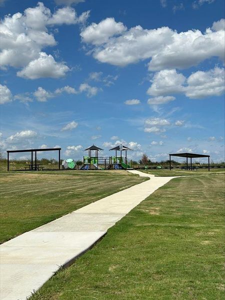 View of home's community featuring a playground and a yard