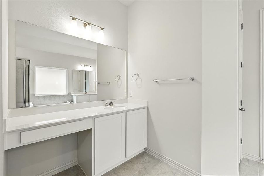 Full bath featuring vanity and light tile patterned floors Full bath featuring vanity and light tile patterned floors