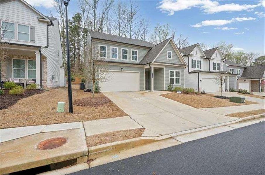 Front exterior of a new home in Enclave at Edgewater, Holly Springs, GA, highlighting curb appeal (Image 27). Front exterior of a new home in Enclave at Edgewater, Holly Springs, GA, highlighting curb appeal (Image 27).