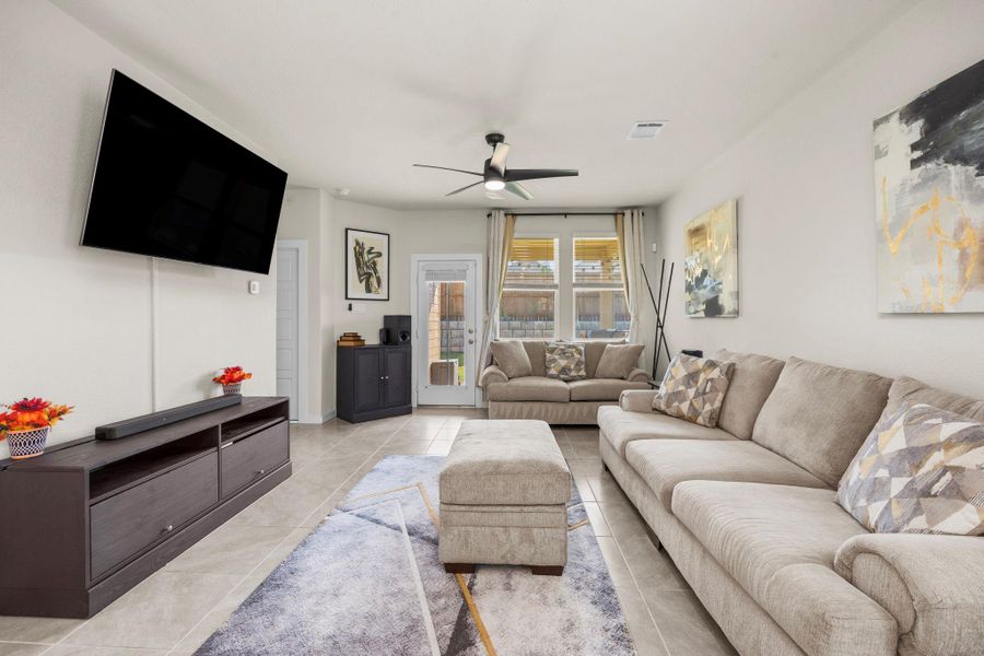 Relax and unwind in this inviting living area. The open layout provides ample space for seating to enjoy your 65' Sony TV, while the large windows offer a great view of the backyard, seamlessly blending indoor and outdoor living.