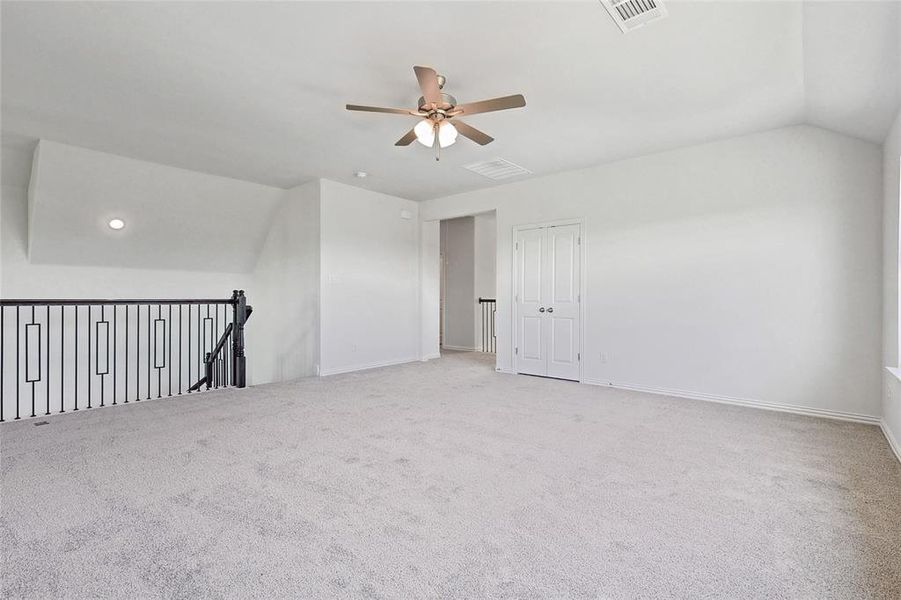 Additional living space featuring ceiling fan, vaulted ceiling, and carpet