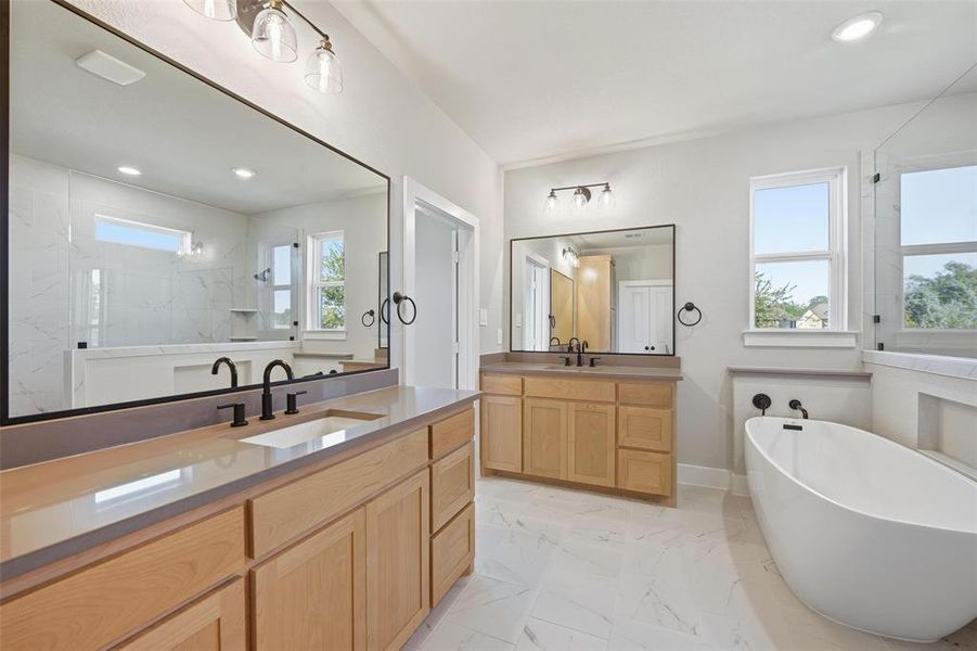 Full bathroom with two vanities, recessed lighting, a soaking tub, light marble finish floors, and a marble finish shower