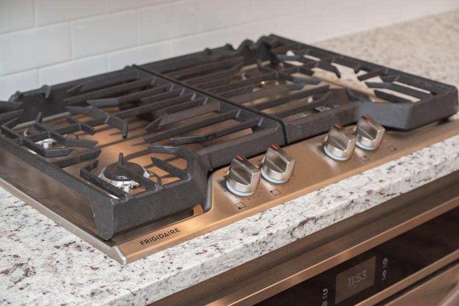 Kitchen view of stainless steel gas stovetop and oven