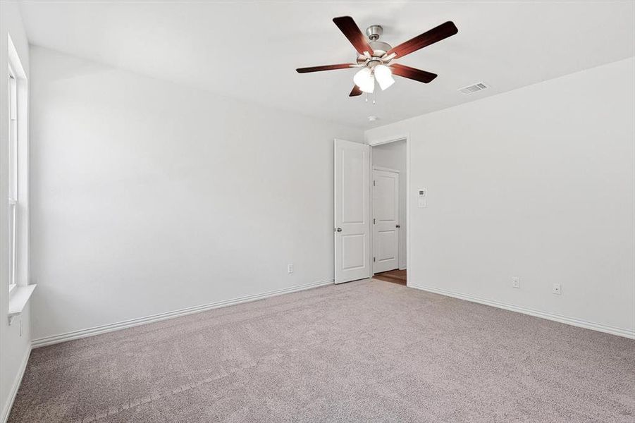 Carpeted empty room with ceiling fan