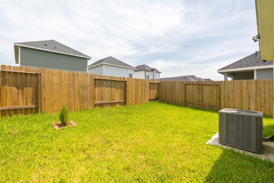 Backyard view with privacy fencing and spacious lawn Backyard view with privacy fencing and spacious lawn