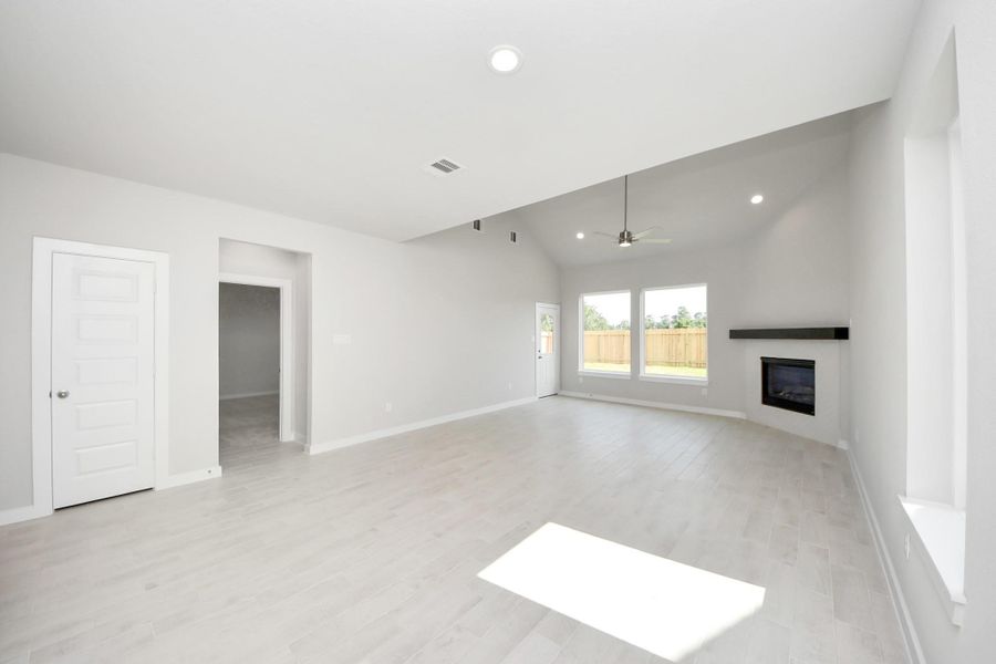 Family room flooded with natural light through the expansive windows. The premium tile flooring adds a touch of luxury to the space, creating the perfect setting for relaxing moments and cherished gatherings with loved ones Family room flooded with natural light through the expansive windows. The premium tile flooring adds a touch of luxury to the space, creating the perfect setting for relaxing moments and cherished gatherings with loved ones