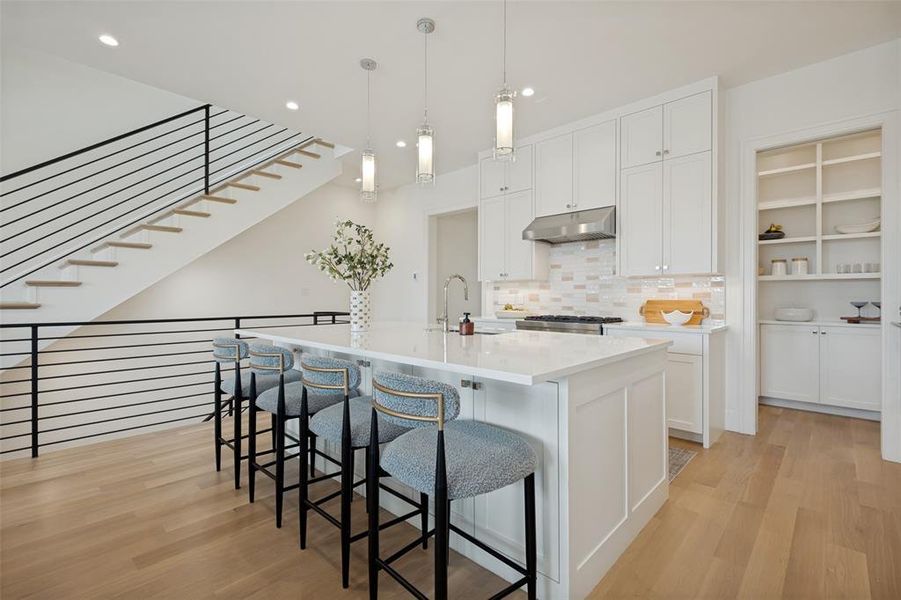 Spacious kitchen featuring an island with breakfast bar seating and a large walk-in pantry for extra storage. Spacious kitchen featuring an island with breakfast bar seating and a large walk-in pantry for extra storage.