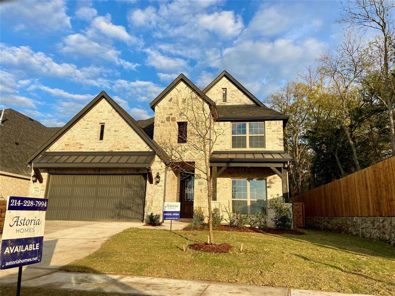 Gorgeous brick & stone 2 story home with metal roof on covered patio & over garage! Trees at rear and side.