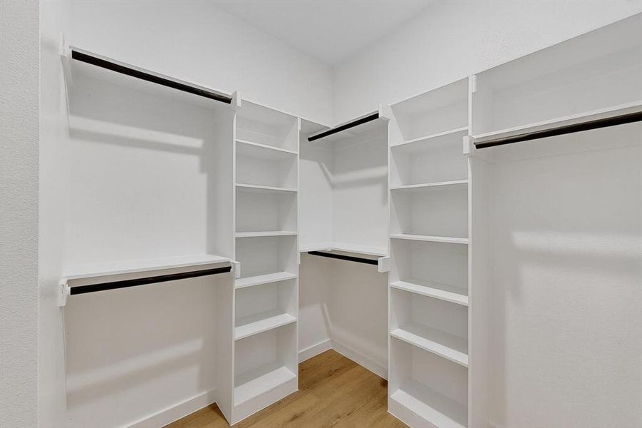 Spacious closet featuring light wood finished floors Spacious closet featuring light wood finished floors