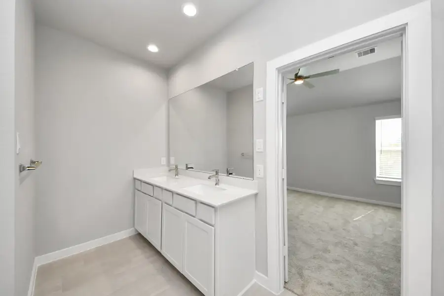 Elevate your daily routine at the elegant vanity, now equipped with double sinks, light countertops, modern hardware, and beautiful recessed lights. Sample photo of completed home with similar floor plan. Actual colors and selections may vary. Elevate your daily routine at the elegant vanity, now equipped with double sinks, light countertops, modern hardware, and beautiful recessed lights. Sample photo of completed home with similar floor plan. Actual colors and selections may vary.