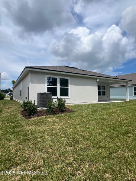 Front exterior of a new home in American Village, Palm Coast, FL, highlighting curb appeal (Image 21).