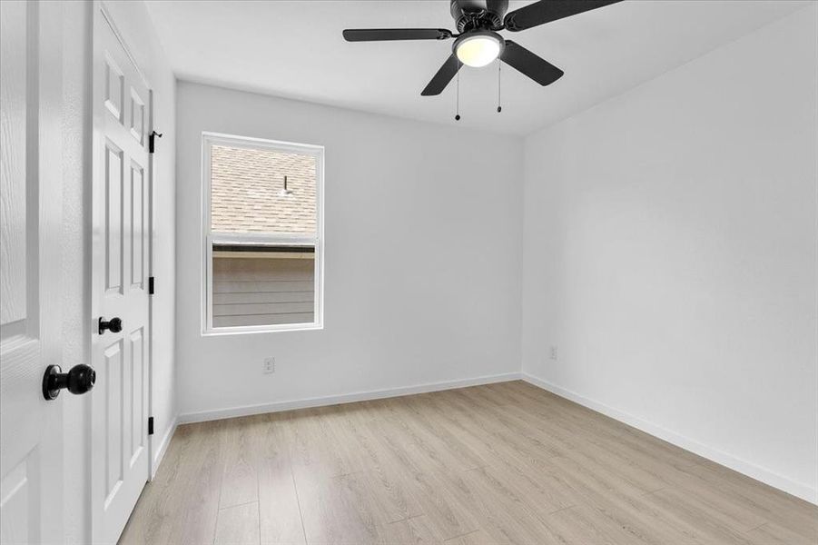 Spare room with ceiling fan and light wood-type flooring