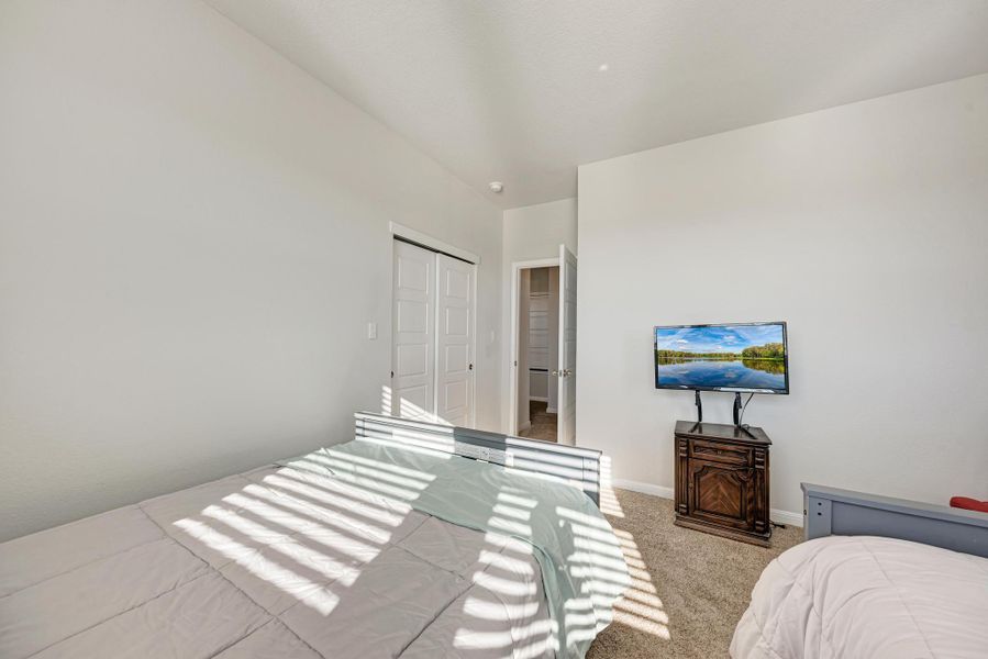 Carpeted bedroom featuring baseboards and a closet