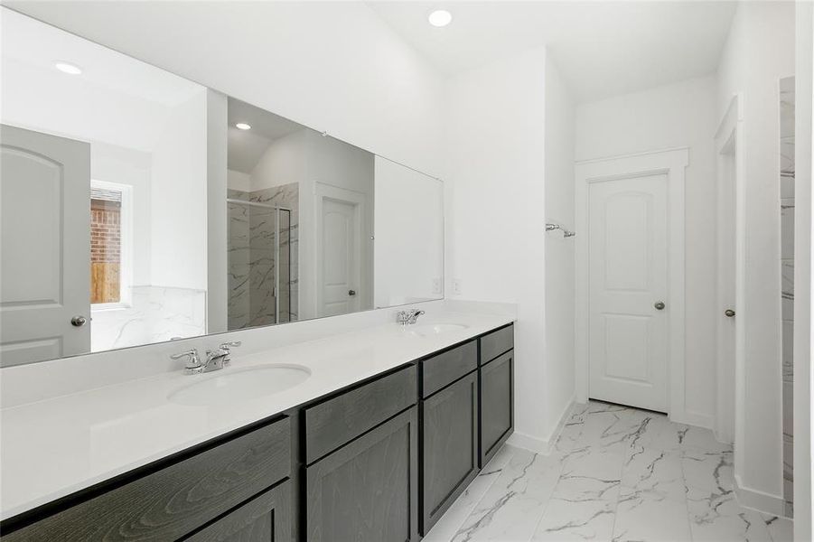 Full bath featuring light marble finish floors, double vanity, a marble finish shower, recessed lighting, and a closet