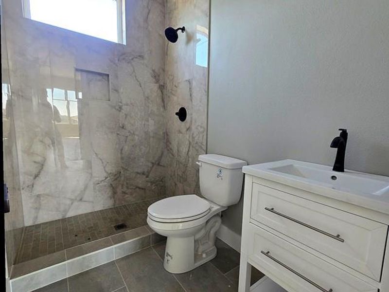 Full bathroom with vanity and a marble finish shower