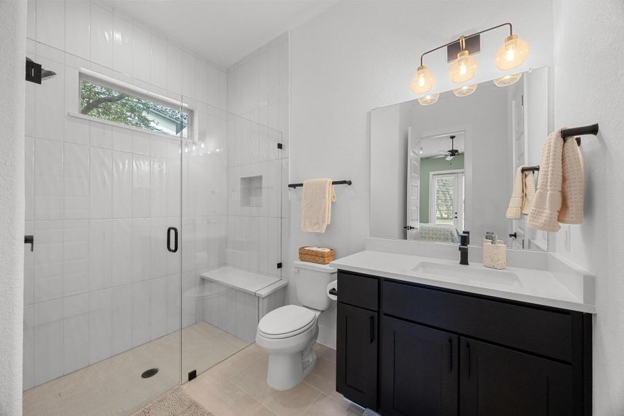 Full bath with healthy amount of natural light, vanity, a shower stall, and tile patterned floors