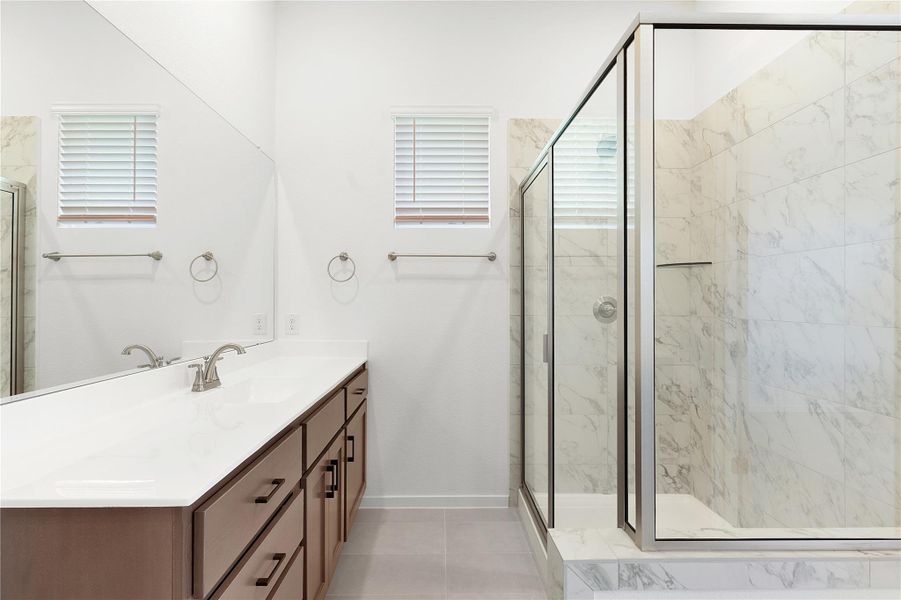 Full bath with vanity, a shower stall, and baseboards
