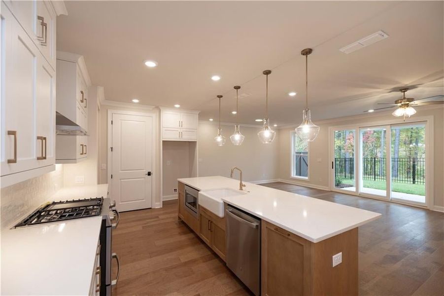 Kitchen with appliances with stainless steel finishes, recessed lighting, open floor plan, a center island with sink, and decorative light fixtures