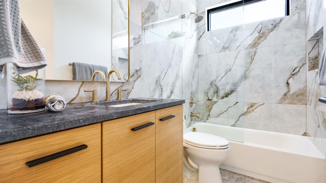 Full bathroom with tiled shower / bath combo, vanity, tile patterned flooring, and toilet