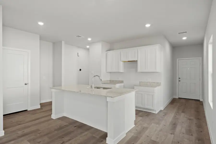 A kitchen with white cabinets.