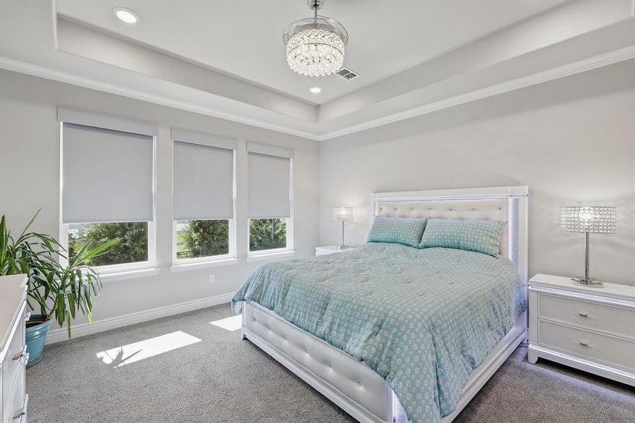 Tray ceiling with recessed lighting and a crystal chandelier