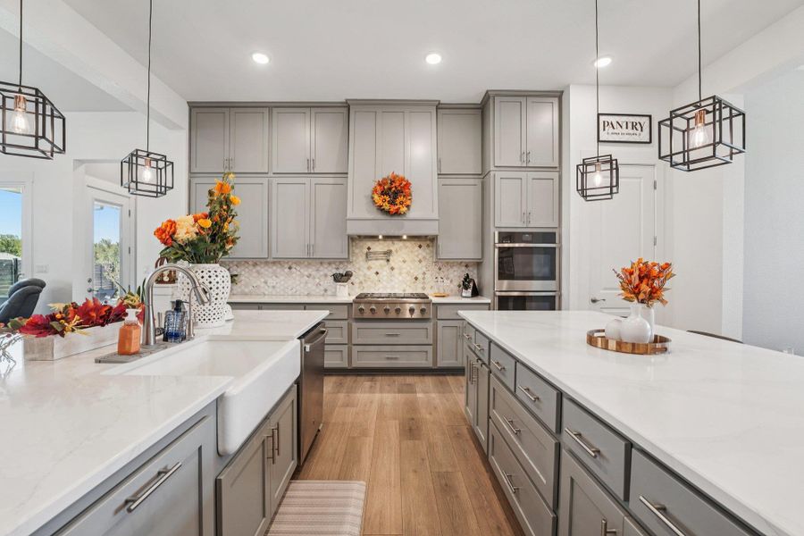 Premier stainless-steel appliances include a gas cooktop with a custom vent hood and double ovens for effortless meal prep.