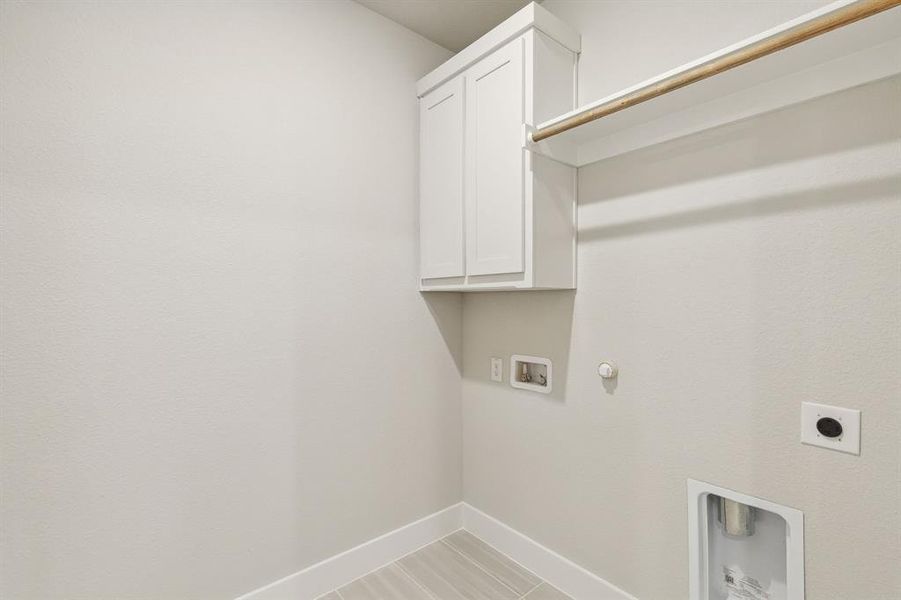 Laundry room featuring cabinets, hookup for an electric dryer, hookup for a gas dryer, and washer hookup