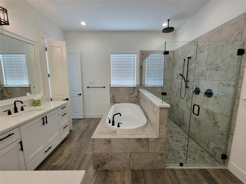 Master bathroom walk in shower with rain head fixture and bench in the shower