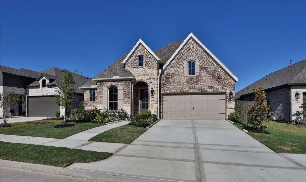 Front exterior of a new home in Riceland 50', Mont Belvieu, TX, highlighting curb appeal (Image 2).