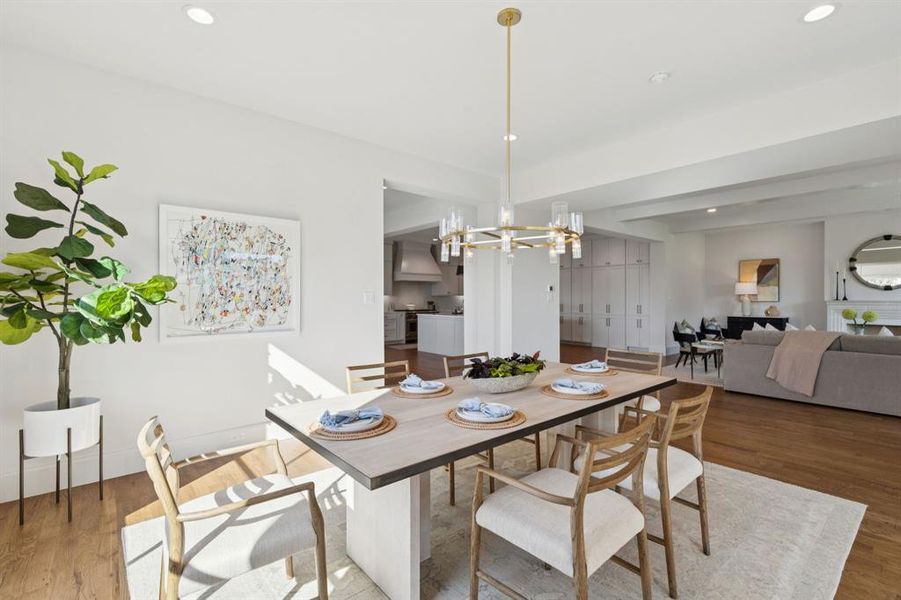 Dining space featuring wood finished floors, recessed lighting, beam ceiling, and a chandelier Dining space featuring wood finished floors, recessed lighting, beam ceiling, and a chandelier