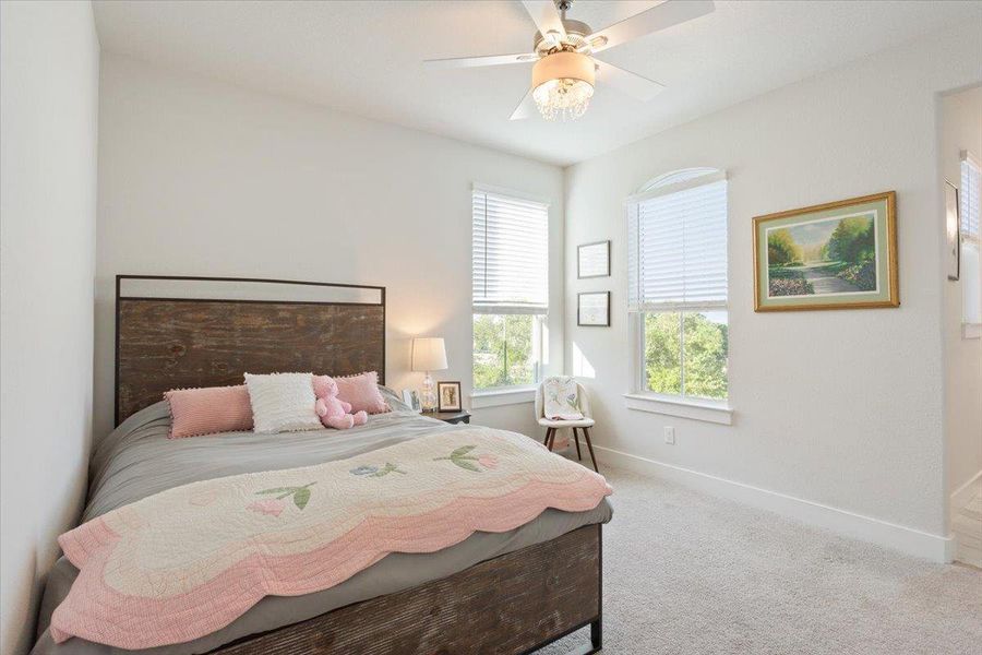 Bedroom with light colored carpet and ceiling fan