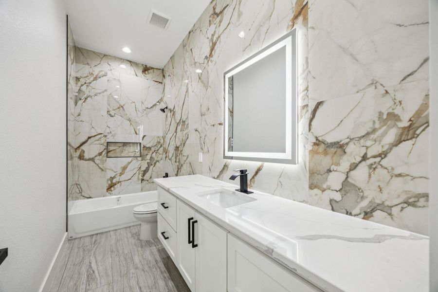 Guest Bathroom features quartz countertops, perfect for durability and lots of storage space! The tile brings a modern feel. Guest Bathroom features quartz countertops, perfect for durability and lots of storage space! The tile brings a modern feel.