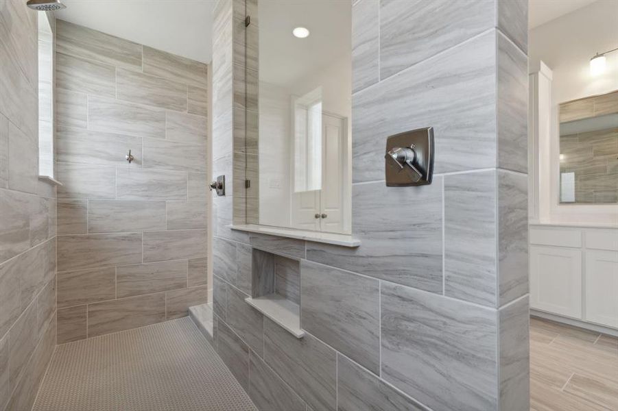 Walk-in shower featuring large format tile walls and a mosaic tile floor Walk-in shower featuring large format tile walls and a mosaic tile floor