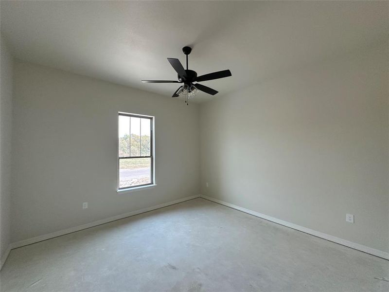 Spare room with concrete floors and a ceiling fan