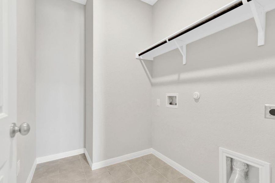 Washroom with hookup for a gas dryer, light tile patterned floors, electric dryer hookup, and washer hookup Washroom with hookup for a gas dryer, light tile patterned floors, electric dryer hookup, and washer hookup