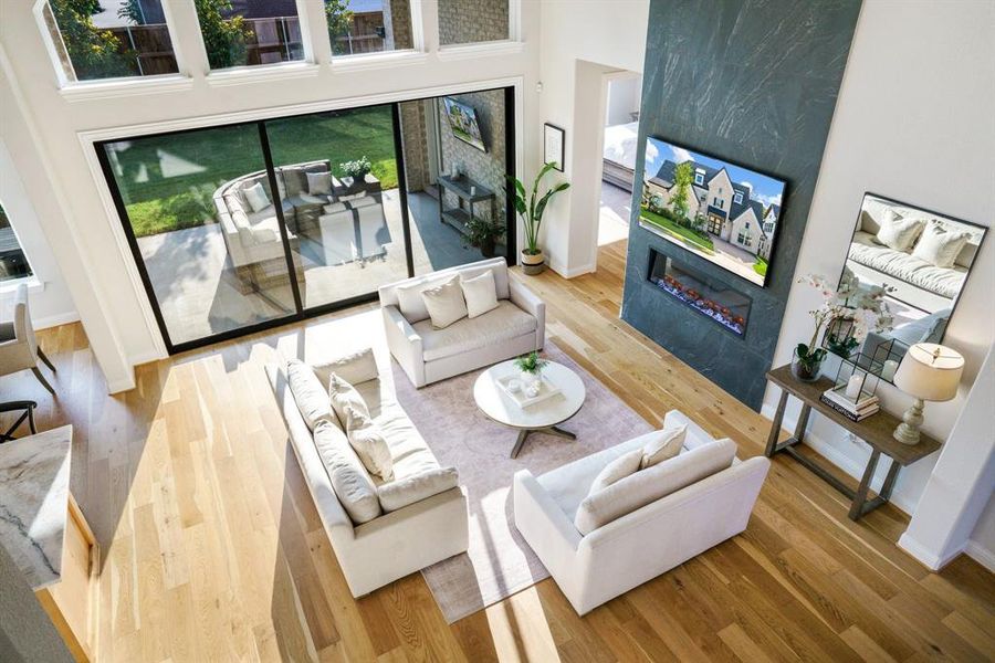 Conversation Central - A view from above reveals room to gather, unwind, and entertain, this living room balances warmth and sophistication. The linear fireplace and custom tile wall make a bold style statement without overwhelming the space. Conversation Central - A view from above reveals room to gather, unwind, and entertain, this living room balances warmth and sophistication. The linear fireplace and custom tile wall make a bold style statement without overwhelming the space.